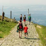 Rodzina wędruje kamienistym szlakiem po górach w Hesji, podziwiając rozległą panoramę doliny.