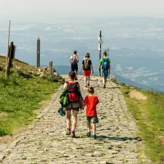 Rodzina wędruje kamienistym szlakiem po górach w Hesji, podziwiając rozległą panoramę doliny.