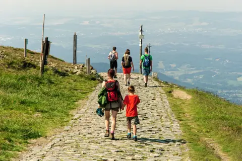 Rodzina wędruje kamienistym szlakiem po górach w Hesji, podziwiając rozległą panoramę doliny.