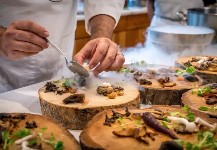 Szef kuchni serwuje danie z grzybami i mgłą, tworząc magiczną atmosferę w jednej z nietypowych restauracji w Warszawie.