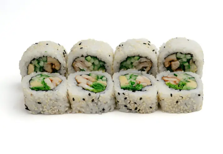 Rząd roladek sushi z ryżem, sezamem i kawałkami unagi, ogórka i awokado.
