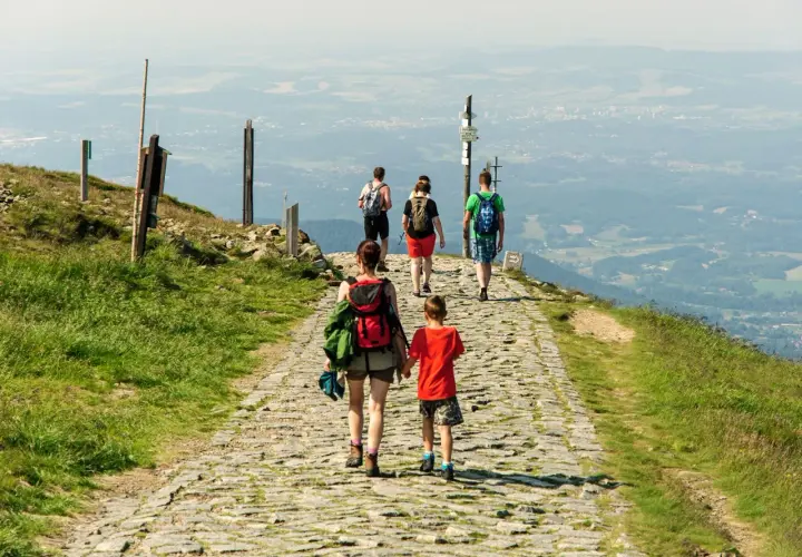 Rodzina wędruje kamienistym szlakiem po górach w Hesji, podziwiając rozległą panoramę doliny.