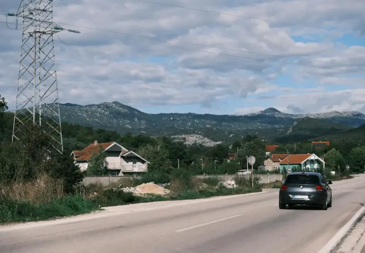Szukasz pomysłu, gdzie jechać w niedzielę? Śląsk oferuje malownicze krajobrazy, domy i góry. Samochód jedzie drogą wśród zieleni.