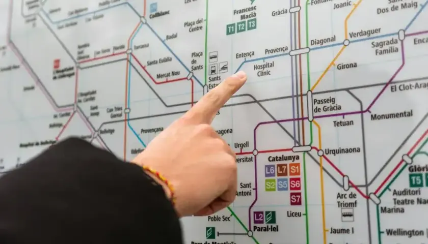 Palec wskazujący na mapę metra w Barcelonie, szukając trasy do Barcelona El Prat.