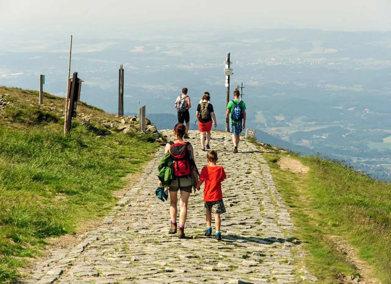 Rodzina wędruje kamienistym szlakiem po górach w Hesji, podziwiając rozległą panoramę doliny.