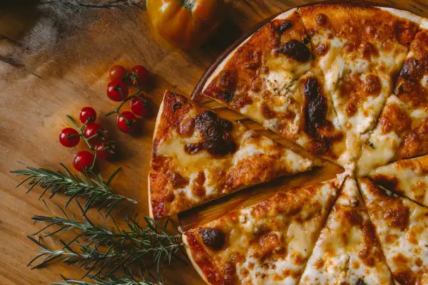 Pyszna pizza z serem i pomidorkami koktajlowymi, idealna do savona menu.