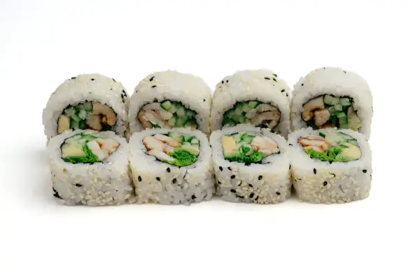 Rząd roladek sushi z ryżem, sezamem i kawałkami unagi, ogórka i awokado.
