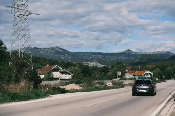 Szukasz pomysłu, gdzie jechać w niedzielę? Śląsk oferuje malownicze krajobrazy, domy i góry. Samochód jedzie drogą wśród zieleni.